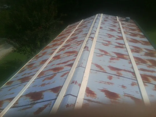 Rusted metal roof panels with new wood purlins before replacement — Storm Damage Roof Repair in Leoma by Roofing Brothers